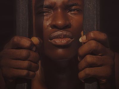 Man's hands gripping a pull-up bar, showing focus.